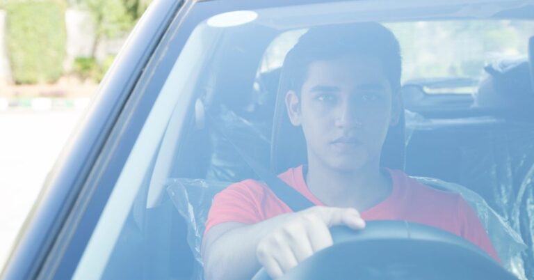 Young driver behind the wheel of a car.