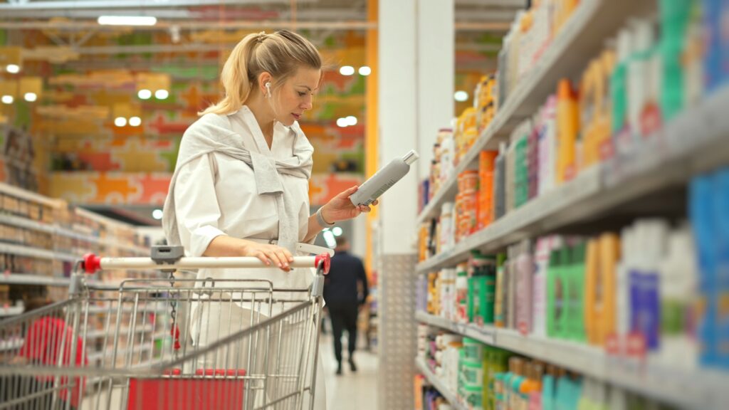 Woman reading product label warning in store