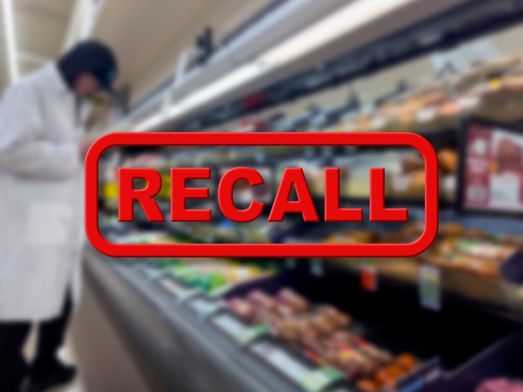 Blurred background of a grocery store employee removing recalled product