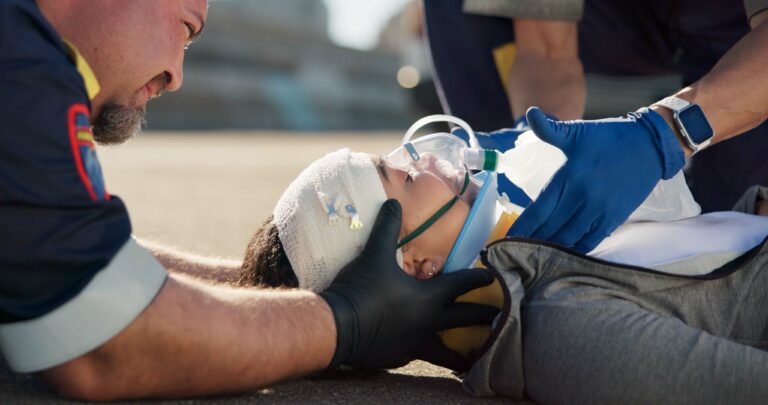 Paramedic helping injured person after accident by doing concussion check